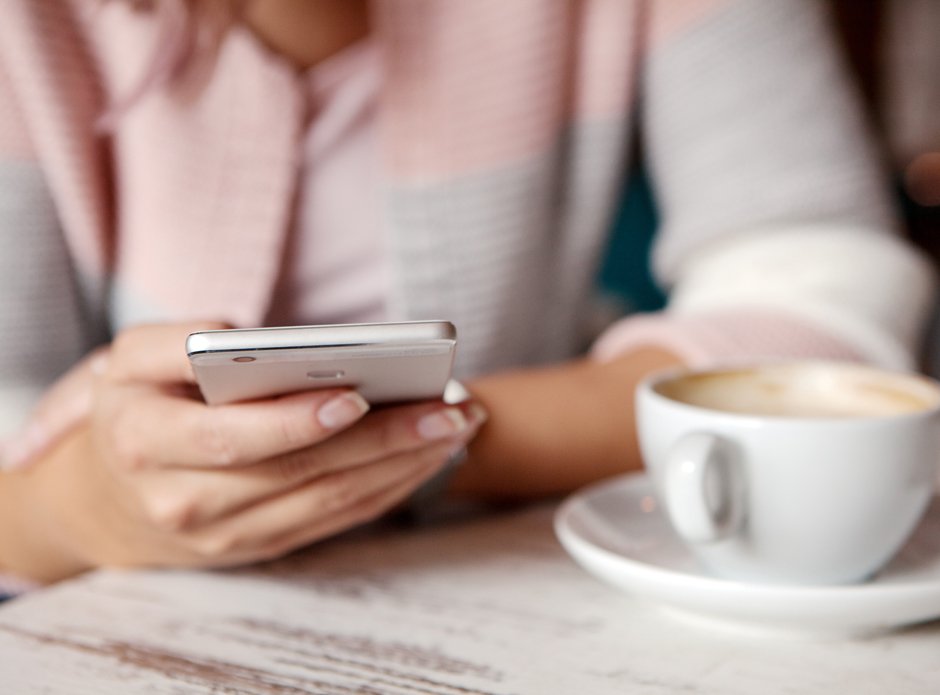 Person Holding Smartphone At Breakfast Table