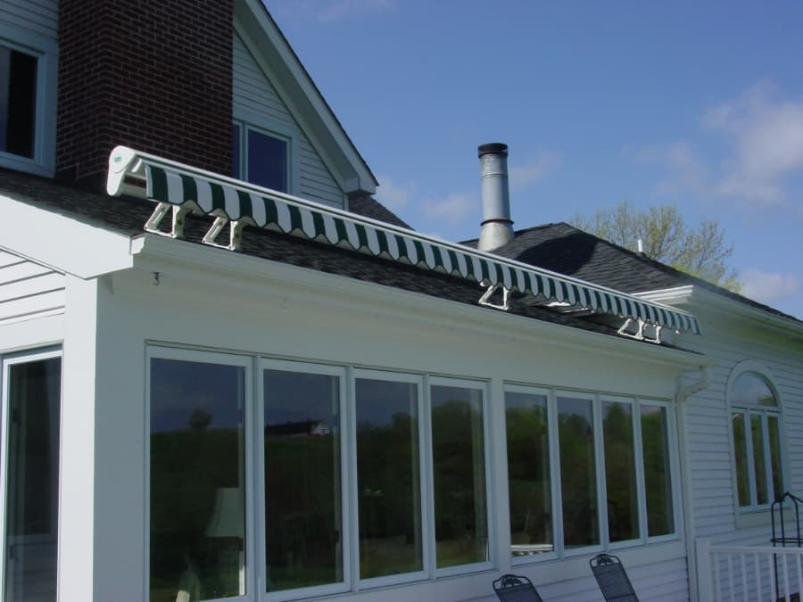 Roof mounted retractable awing on a white house